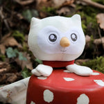 Doudou bébé chouette : Violette dans un décor dans un jardin