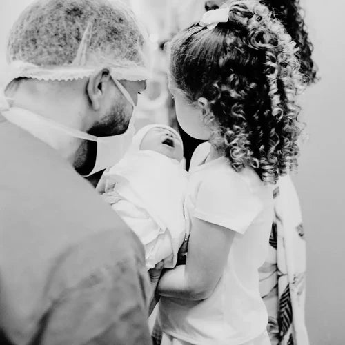 Papa et sa petite fille portant un nouveau-né